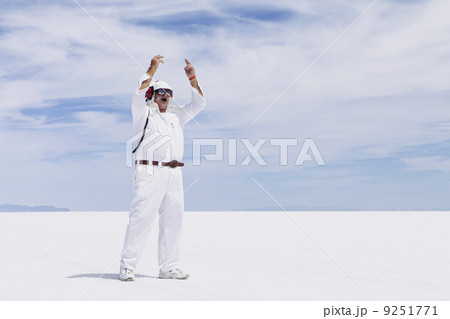 A man in white overalls, with a radio headset, a race official timekeeper at a car racing event, Speed Week. 9251771