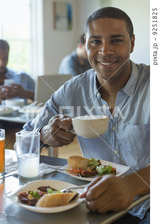 A group of men and women in a cafe, eating and drinking and enjoying each other's company. A group of men and women in a cafe, eating and drinking and enjoying each other's company. 9251825