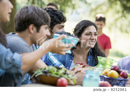 Adults and children around a table at a party in a garden.  9252061