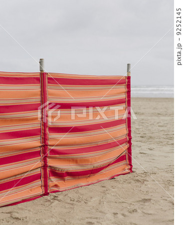 A red striped windbreak on Cannon Beach on the Oregon coast. A red striped windbreak on Cannon Beach on the Oregon coast. 9252145