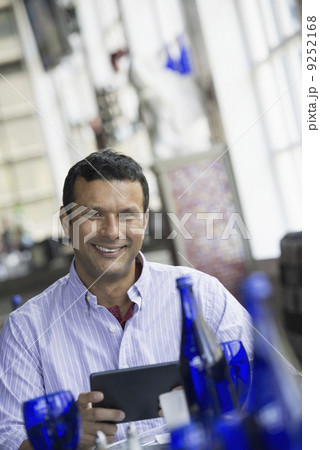A cafe interior. A man sitting using a digital tablet. A cafe interior. A man sitting using a digital tablet. 9252168