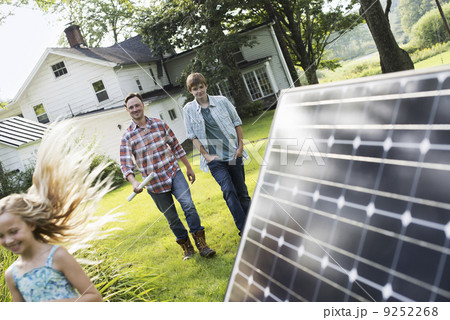 Two people walking towards a farmhouse garden.  9252268