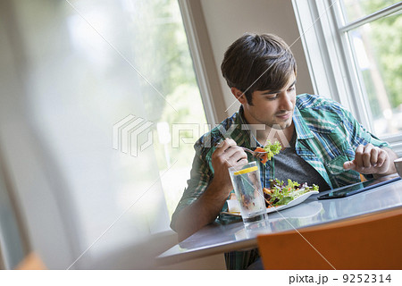 A young man using a digital tablet.  9252314