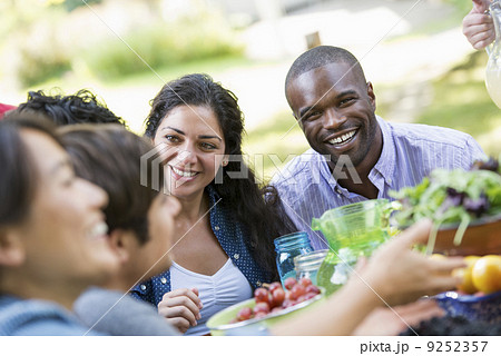 Adults and children around a table in a garden.  9252357