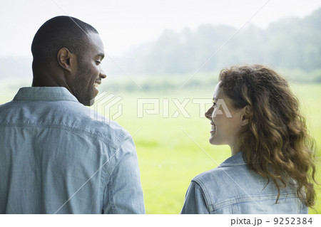 A young man and woman, a couple standing side by side. Looking at each other.  9252384