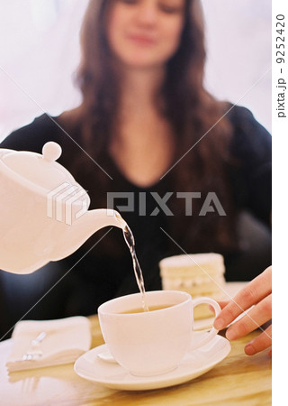 A woman pouring a cup of tea A woman pouring a cup of tea 9252420