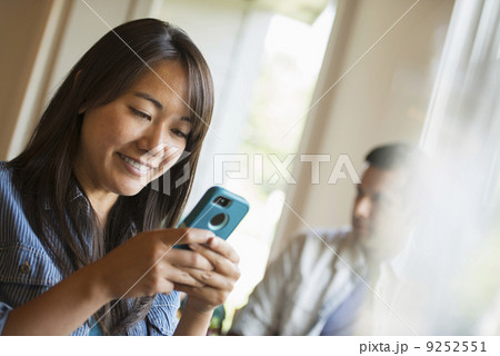 A woman checking her smart phone, in a cafe.  9252551