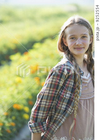Summer on an organic farm. A young girl in a field of flowers. 9252554