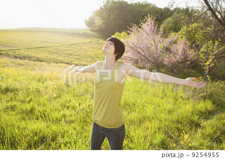 Young Woman Standing In Grassy Field In Spring. 9254955