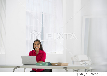 Asian Businesswoman Seated At Desk Using A Laptop. Asian Businesswoman Seated At Desk Using A Laptop. 9254966
