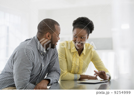Office Interior. Two People, A Couple At A Table Using A Digital Tablet. Office Interior. Two People, A Couple At A Table Using A Digital Tablet. 9254999