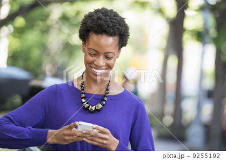 City. A Woman In A Purple Dress Checking Her Smart Phone. 9255192