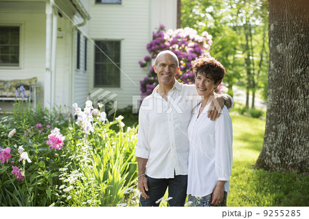 Organic Farm. Summer Party. A Mature Couple In White Shirts Standing Together Among The Flowers. Organic Farm. Summer Party. A Mature Couple In White Shirts Standing Together Among The Flowers. 9255285