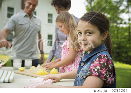A Summer Family Gathering At A Farm. A Girl Slicing And Juicing Lemons To Make Lemonade. A Summer Family Gathering At A Farm. A Girl Slicing And Juicing Lemons To Make Lemonade. 9255292