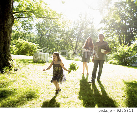On The Farm. Two Adults Carrying Cartons Of Fresh Vegetables And Plants. A Girl Carrying Bunches Of Fresh Herbs. On The Farm. Two Adults Carrying Cartons Of Fresh Vegetables And Plants. A Girl Carrying Bunches Of Fresh Herbs. 9255311