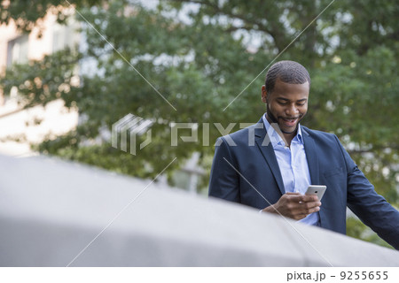 Summer. A Man In A Blue Jacket And Open Collared Shirt Using A Smart Phone. Summer. A Man In A Blue Jacket And Open Collared Shirt Using A Smart Phone. 9255655