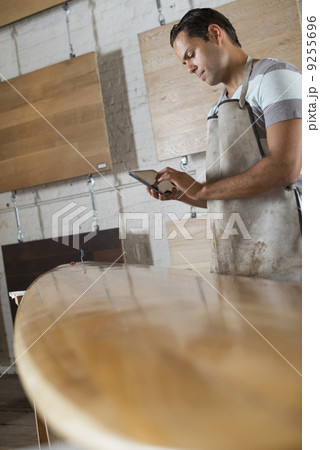 A Young Man In A Workshop. Using A Digital Tablet To Keep Records And Photograph Objects. 9255696