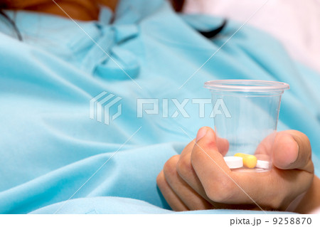 Patient with pill in hands Patient with pill in hands 9258870