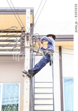 Electrician connects wires on a pole Electrician connects wires on a pole 9265656