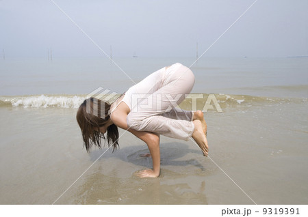 asian girl performing yoga on a beach asian girl performing yoga on a beach 9319391