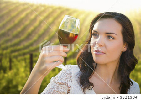 Young Adult Woman Enjoying A Glass of Wine in Vineyard 9321984