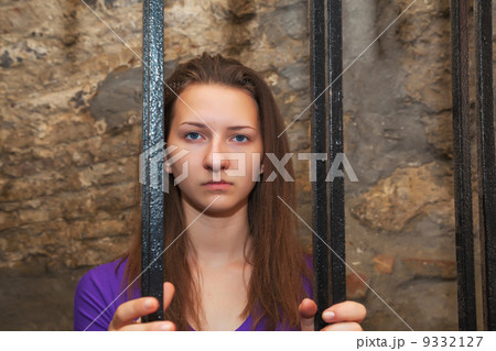 Young woman behind the bars 9332127