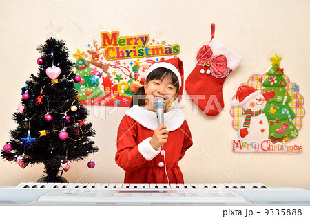 マイクで歌うサンタクロース衣装の女の子 9335888