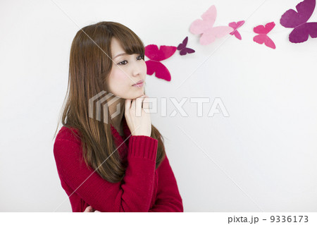 白い壁際の若い女性 9336173