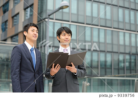 書類を見る二人のビジネスマン 書類を見る二人のビジネスマン 9339756