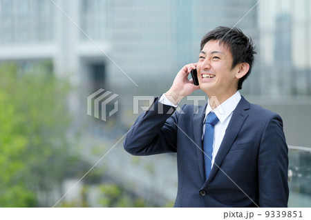 スマートフォンで話す若いビジネスマン スマートフォンで話す若いビジネスマン 9339851