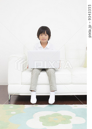 リビングでパソコンをする男の子 9343355