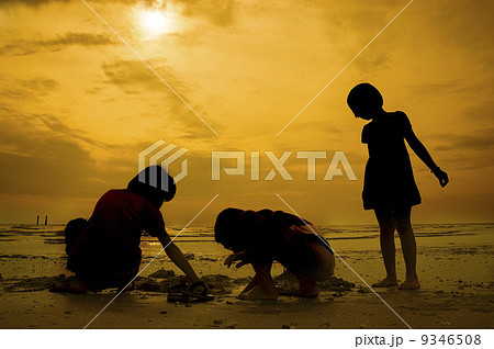 Silhouette group of kids playing at the beach 9346508