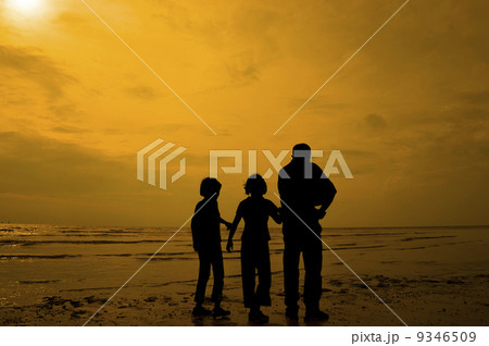 Silhouette of kids playing at the beach 9346509