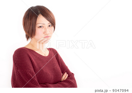 腕組みをして不機嫌そうに睨む若い女の子 9347094