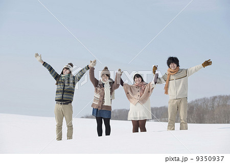雪原で手をつなぐ大学生 9350937