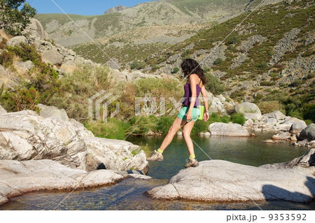 walking woman on a rock at a Gredos river 9353592