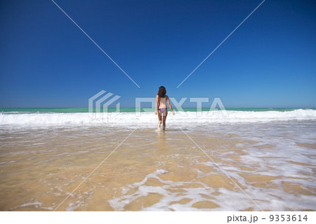 woman running to the ocean at Conil beach 9353614