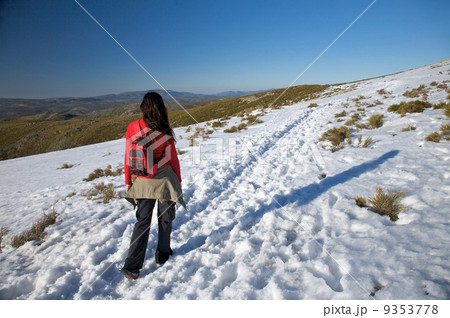 woman with rucksack on snow path 9353778