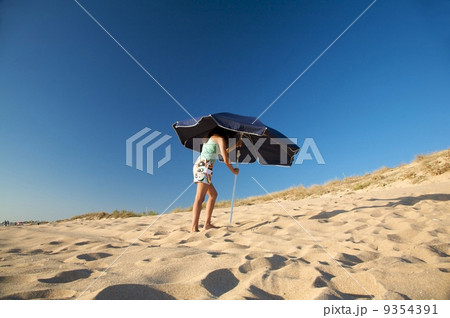 woman placing parasol woman placing parasol 9354391