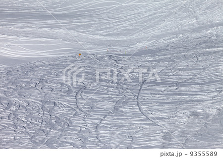 Traces of skis and snowboards in new-fallen snow on off-piste sl 9355589