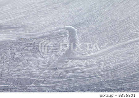 Off-piste slope and snowy road with trace from ski and snowboard 9356801