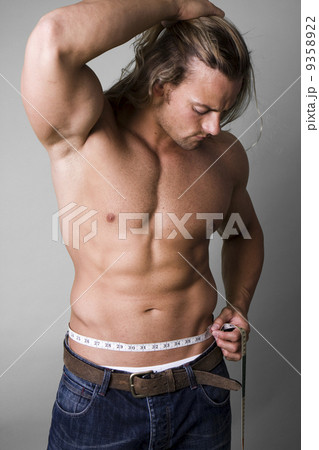 Muscular man measuring his waist 9358922