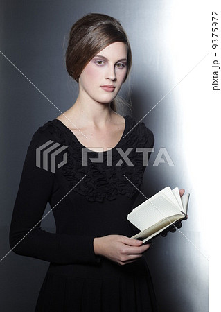 woman in black dress holding book in her hands woman in black dress holding book in her hands 9375972