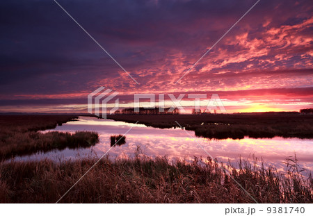 dramatic red fire sunrise over river 9381740