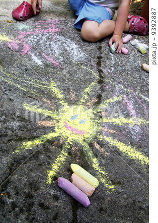 Childs painting on the pavement 9392887