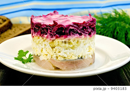 Herring with vegetables in white plate on a board 9403183