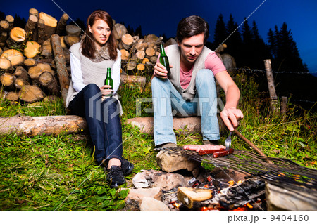 Alps - Couple at campfire in mountains Alps - Couple at campfire in mountains 9404160