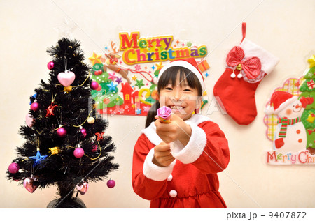 クラッカーを鳴らすサンタクロース衣装の女の子 9407872