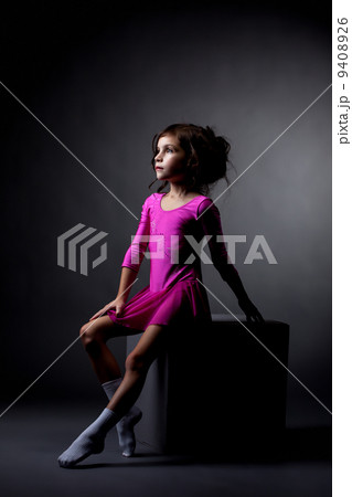Pretty rhythmic gymnast sitting on cube in studio Pretty rhythmic gymnast sitting on cube in studio 9408926