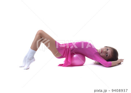 Cute little gymnast posing lying in studio 9408937